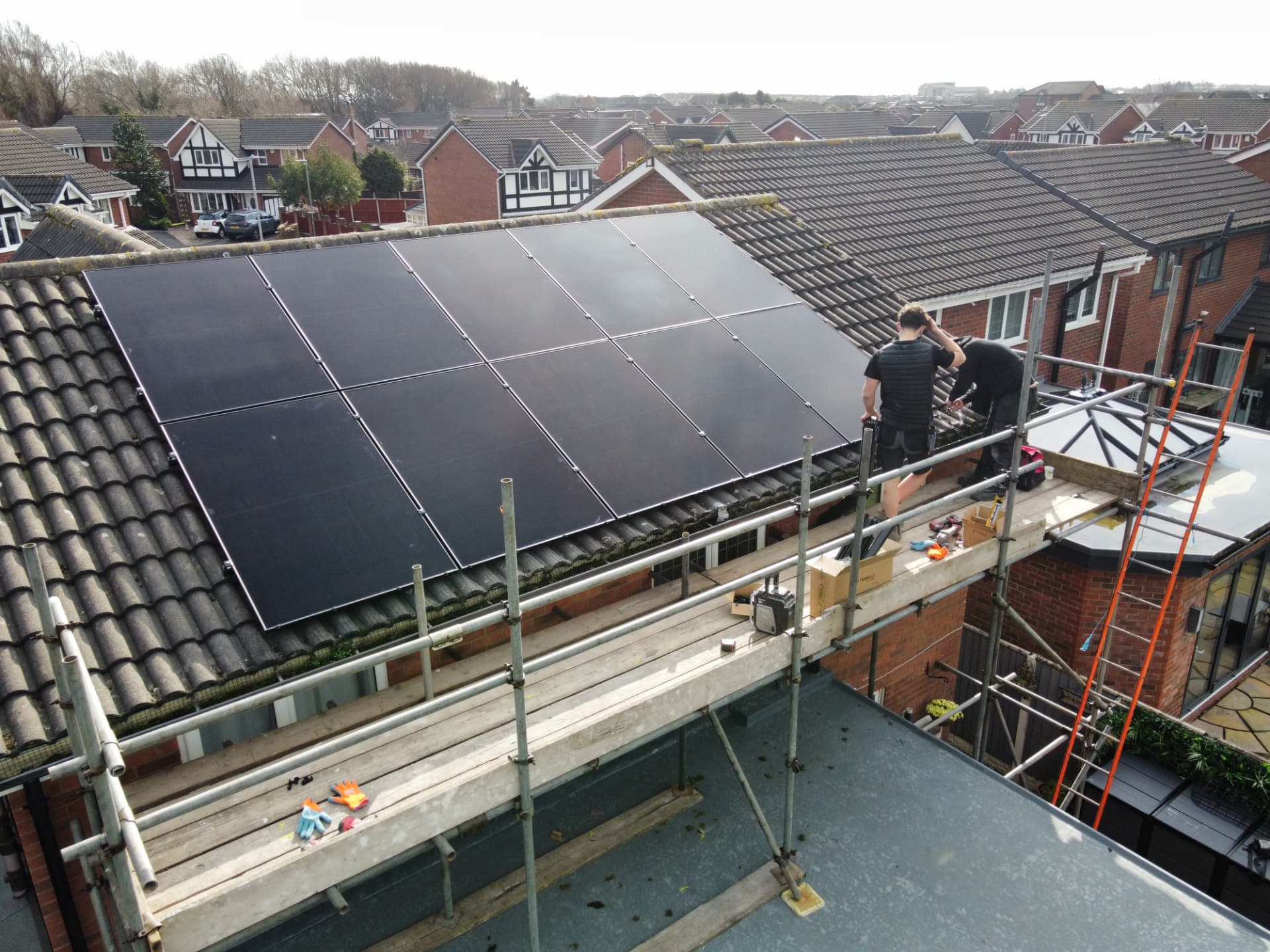 Drone view of ten all-black solar panels being fitted on a tiled roof in Poulton-le-Fylde