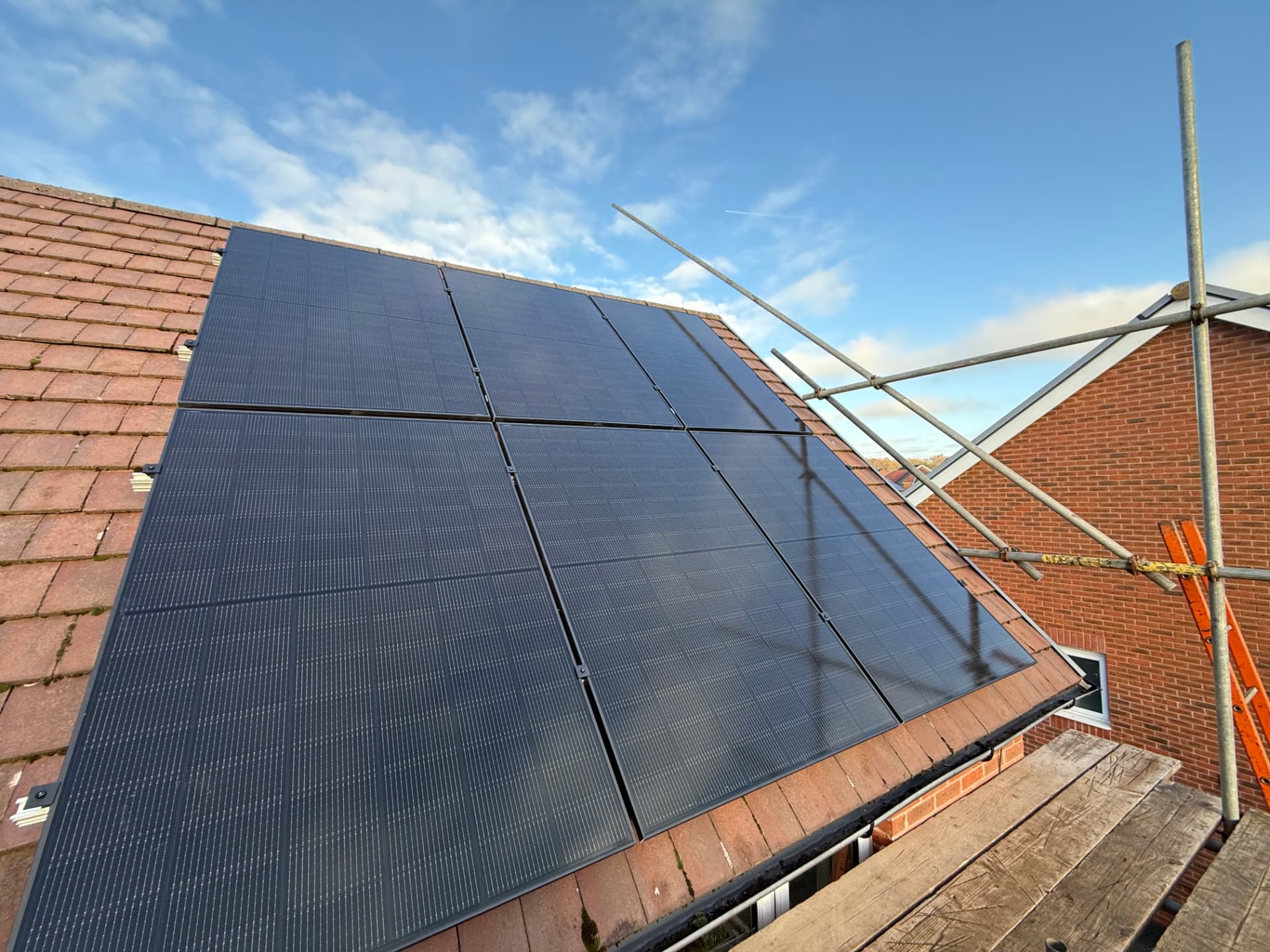 Eleven solar panels on a tiled roof in Buckshaw Village, photographed from scaffolding