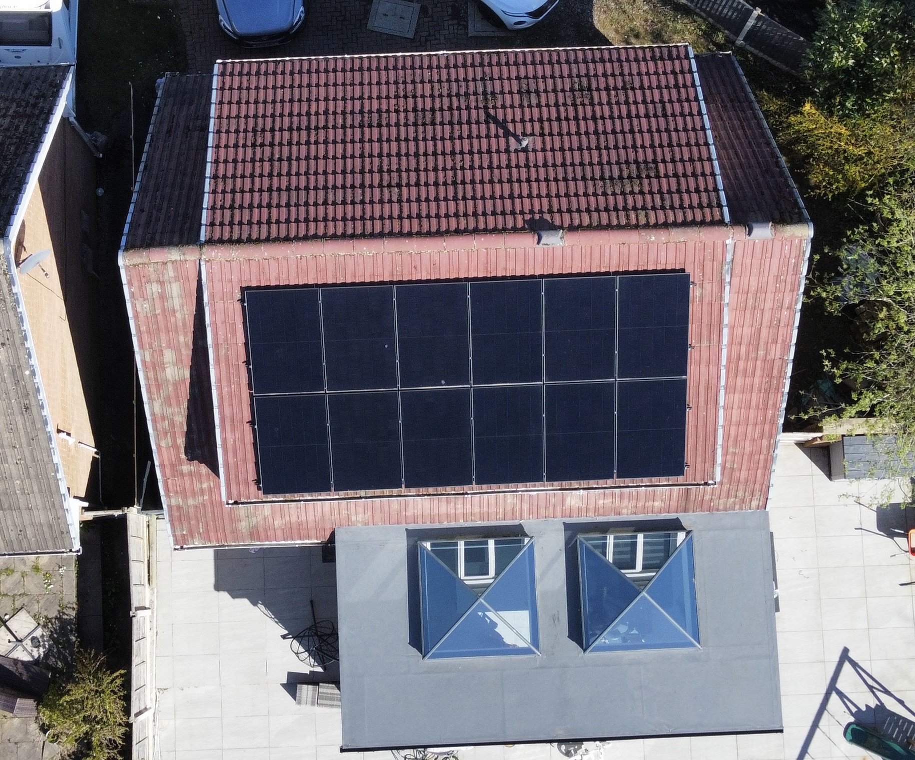 Drone view of 12 solar panels installed on a red-tiled Chorley roof using a hook and rail mounting system